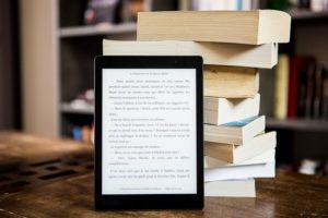 重ねられた紙の本と電子書籍、2020年8月3日(金)に開催する東京読書交換会vol.109の広報、机の上に置かれていて背景は書棚、読書会@オンライン(記事内挿入画像)