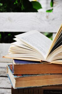 3冊のハードカバー本が積まれている、2026年9月26日（土）に開催する東京読書交換会 vol.271の広報、本は屋外のベンチの上に置かれている、読書会＠池袋